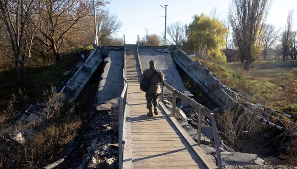 Un hombre pasa junto a un puente destruido en Vovchans'k, región de Kharkiv, el 1 de noviembre de 2022, en medio de la invasión rusa de Ucrania. (Foto de Yevhen TITOV / AFP)