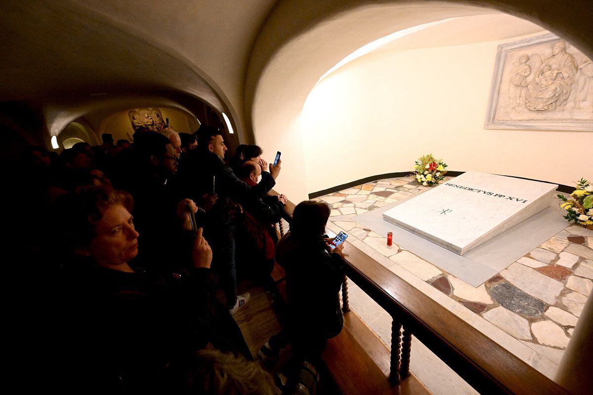 People pay homage to the tomb of the late Pope Emeritus Benedict XVI in Saint Peter's Basilica in the Vatican on January 8, 2023. (Photo by Vincenzo PINTO / AFP)