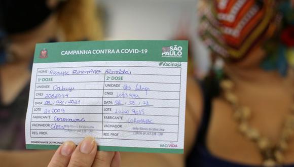Una mujer indígena muestra su cartilla de vacunación luego de recibir la segunda dosis de la vacuna contra el coronavirus CoronaVac (COVID-19) de Sinovac en una estación de salud, en Guarulhos, cerca de Sao Paulo, Brasil. (Foto: REUTERS / Carla Carniel).