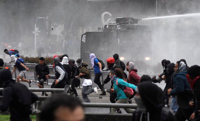 Los manifestantes se enfrentan a las fuerzas de seguridad durante una protesta en Santiago de Chile. (REUTERS / Jose Luis Saavedra).