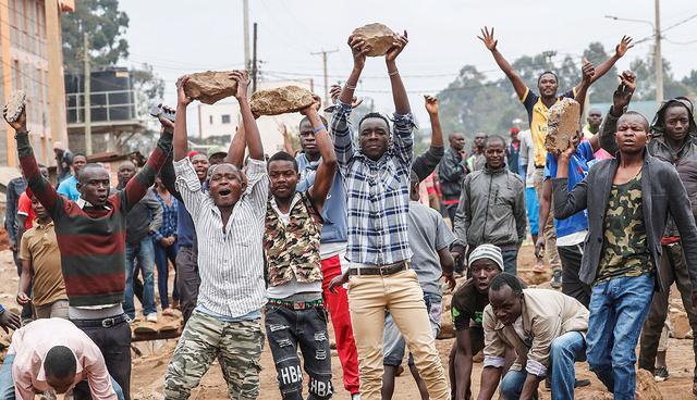 Supporters of opposition leader Raila Odinga hold up boulders in front of a barricade in Kawangware slum in Nairobi, Kenya, August 10, 2017.   REUTERS/Goran Tomasevic