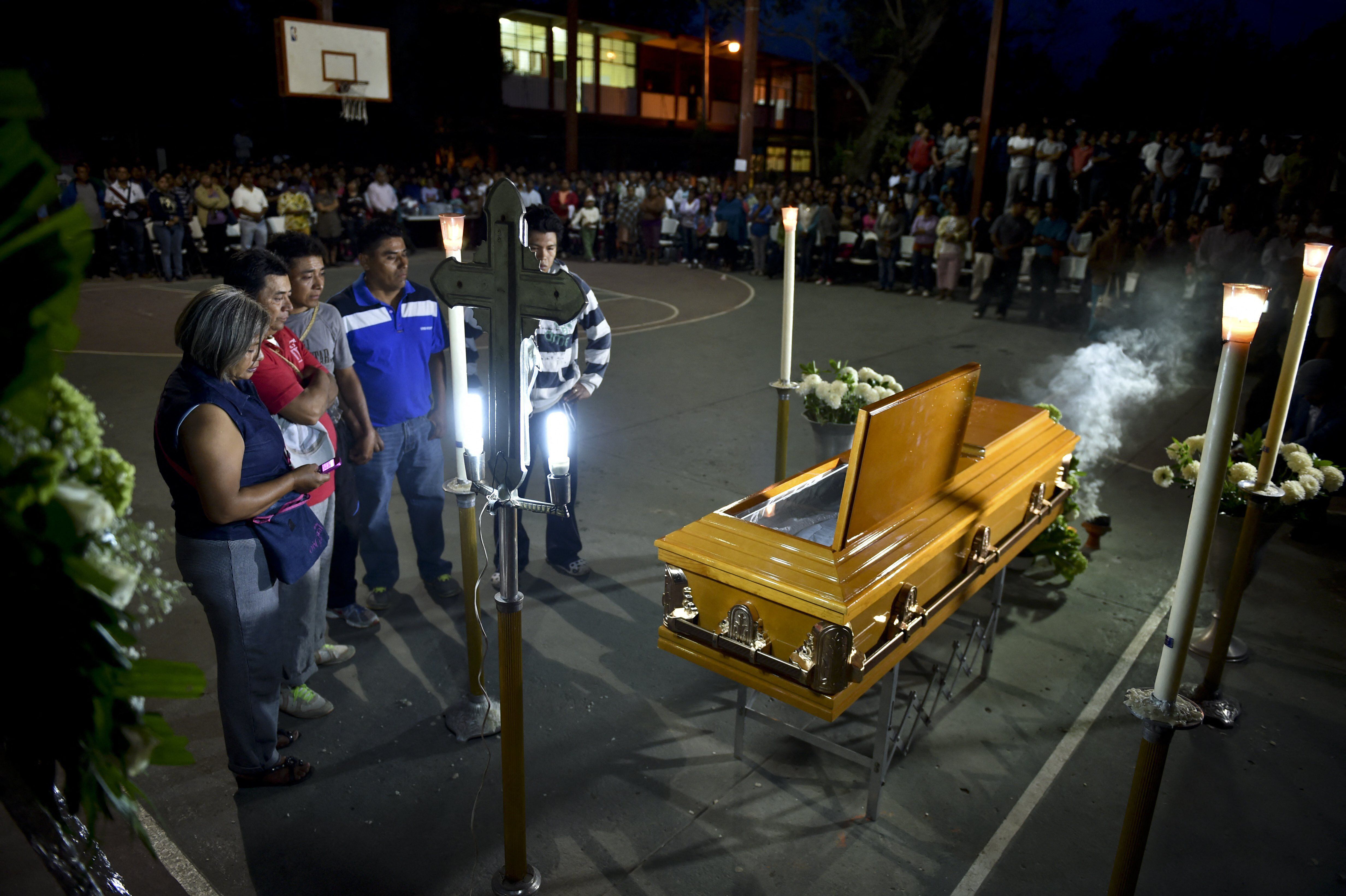The parents and relatives of student Julio César Ramírez Nava attend his wake on September 30, 2014. (Photo by YURI CORTEZ / AFP).
