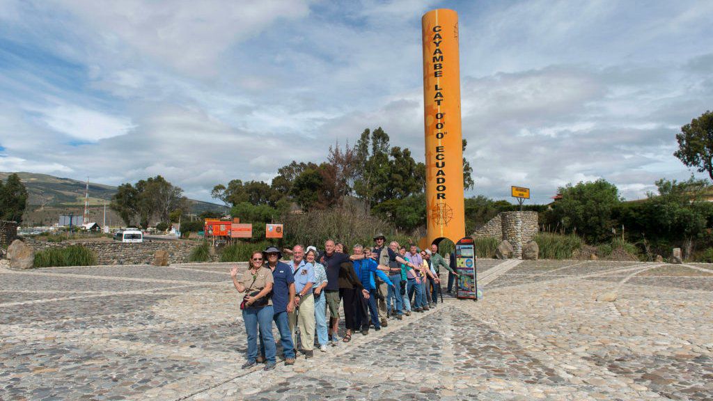 Tourists with one foot in the northern hemisphere and the other in the southern hemisphere at the Quitsato equator monument and sundial near Cayambe, near Quito.  (GETTY IMAGES)