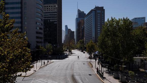 Un hombre camina por una desértica céntrica avenida comercial en Santiago de Chile durante una nueva jornada de confinamiento ante el avance de la pandemia de coronavirus COVID-19. (Foto: EFE/ Alberto Valdes).
