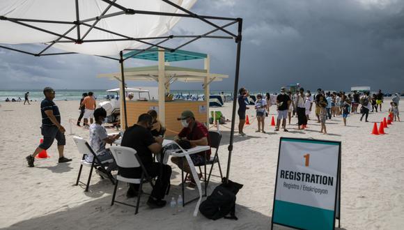 Las personas se registran para recibir una vacuna Johnson & Johnson contra el coronavirus Covid-19 en un centro de vacunación en la playa, en South Beach, Florida. (Foto de Eva Marie UZCATEGUI / AFP).