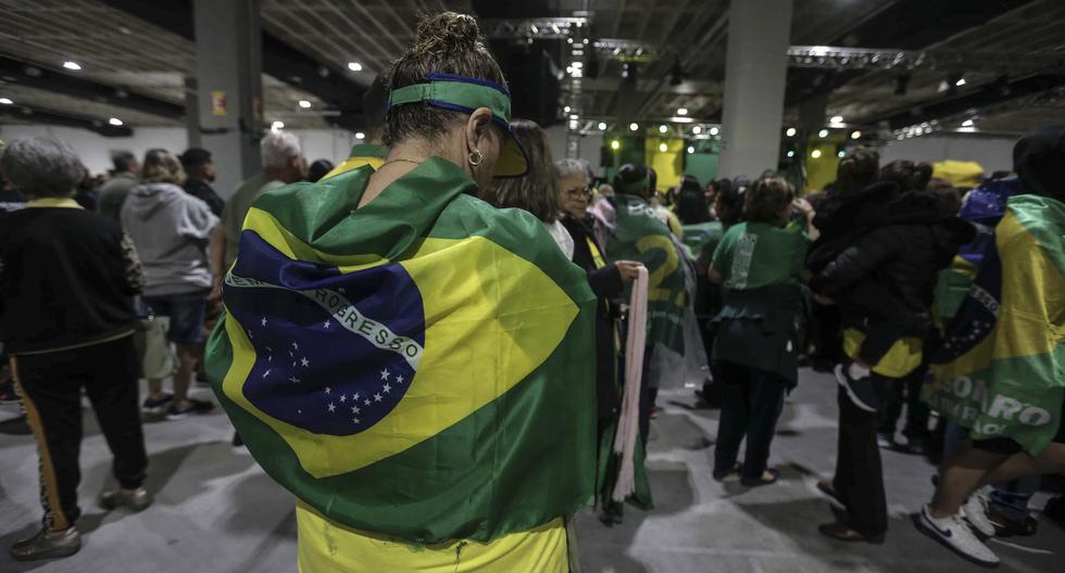 Los simpatizantes del presidente de Brasil y candidato a la reelección, Jair Bolsonaro, han adoptado los emblemas patrios y la camiseta de la selección como distintivos. En la imagen, sus seguidores asisten a un mitin de campaña en Santos.  EFE/ Guilherme Dionísio