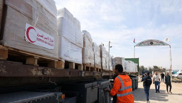 La gente se reúne alrededor de camiones que transportan ayuda humanitaria que entró en la Franja de Gaza desde Egipto a través del cruce fronterizo de Rafah el 21 de octubre de 2023. (Foto de Mohammed ABED / AFP)