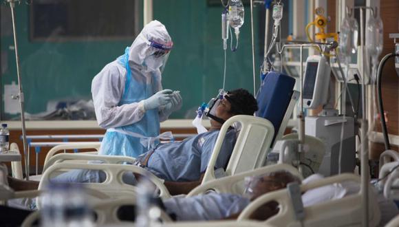 Un personal médico con traje de Equipo de Protección Personal (EPI) atiende a un paciente con coronavirus COVID-19 en la Unidad de Cuidados Intensivos del Hospital Sharda, en Noida. (Foto: Archivo/AFP / XAVIER GALIANA9.
