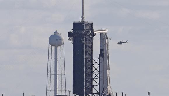 Un helicóptero de seguridad de la NASA que acompaña a la caravana de los astronautas vuela sobre el cohete SpaceX Falcon 9 mientras se encuentra en la plataforma de lanzamiento 39A antes de su lanzamiento, en el Centro Espacial Kennedy en Florida el 5 de octubre de 2022. (Foto de Gregg Newton / AFP)