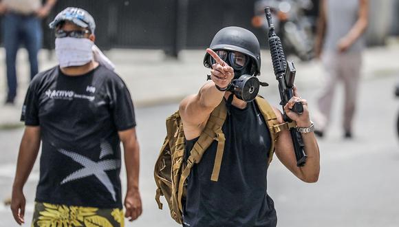 VEN05. CARACAS (VENEZUELA), 20/07/21017.- Un manifestante opositor sostiene un rifle de alto calibre durante un enfrentamiento con la Guardia Nacional Bolivariana (GNB) en las inmediaciones de la planta televisiva estatal VTV durante el paro general de 24 horas convocado por la oposiciÛn hoy, jueves 20 de julio de 2017, en Caracas (Venezuela). Miembros de la GNB comenzaron a dispersar las protestas en la vÌa p˙blica de varias zonas de Caracas que desarrollan los opositores en el marco de un "paro cÌvico nacional" de 24 horas. El presidente de Venezuela, Nicol·s Maduro, pidiÛ hoy a la justicia del paÌs "actuar inmediatamente" contra el alcalde opositor Carlos Ocariz, a quien responsabilizÛ de un "ataque" a la planta televisiva estatal VTV, al tiempo que ordenÛ "capturar a todos los terroristas" implicados en el suceso. EFE/Miguel GutiÈrrez