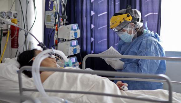 Un trabajador de la salud revisa a un paciente que padece COVID-19 en la UCI del Hospital San Roque en Córdoba, Argentina. (Foto: Nicolás Aguilera / AFP)
