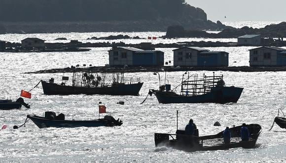 Un pescador conduce un bote en un puerto en la isla de Pingtan, frente a Taiwán, en la provincia de Fujian, sureste de China, el 9 de abril de 2023. (Foto de GREG BAKER / AFP)