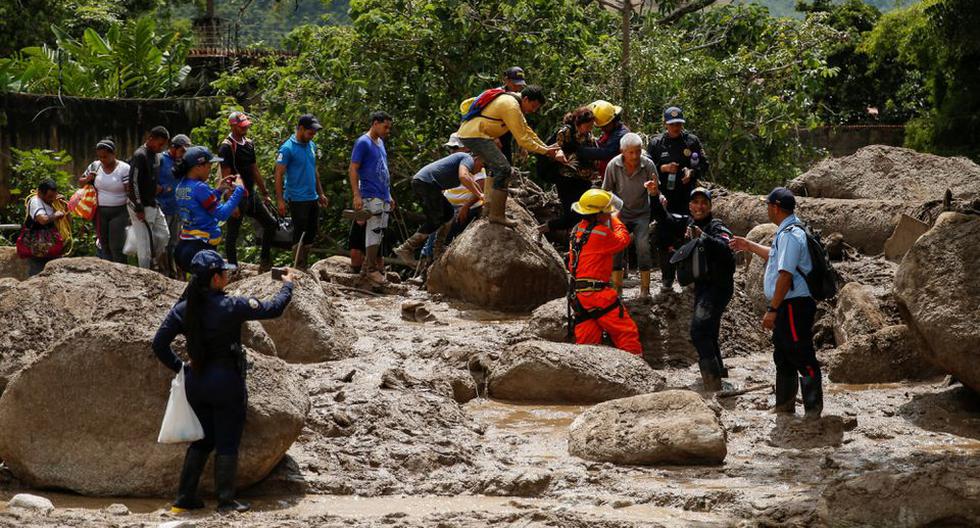 El equipo de rescate ayuda a las personas a evacuar después de las devastadoras inundaciones que siguieron a las fuertes lluvias en el barrio de Los Castanos, en Maracay, estado de Aragua, Venezuela. (REUTERS/Leonardo Fernandez Viloria).