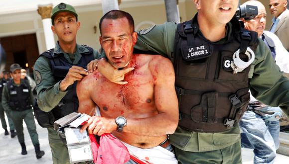 Un atacante chavista recibió una dura agresión de opositores cuando irrumpió en el Congreso de Venezuela. (Foto: REUTERS)