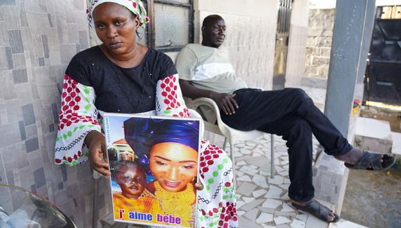 Mariama Kuyateh, de 30 años, sostiene una foto de su difunto hijo Musa, quien murió de insuficiencia renal aguda, en Banjul el 10 de octubre de 2022. (Foto de MILAN BERCKMANS / AFP)