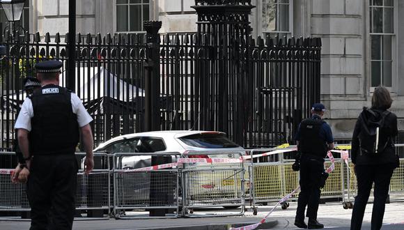 Los oficiales de policía trabajan cerca de un automóvil, visto en las puertas de Downing Street, en Whitehall, en el centro de Londres, el 25 de mayo de 2023. (Foto de JUSTIN TALLIS / AFP)