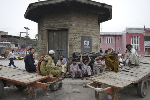 Trabajadores se sientan en la carretera durante un bloqueo nacional impuesto por el gobierno como medida preventiva contra el coronavirus, en Rawalpindi. (Foto: AFP/Farooq Naeem)