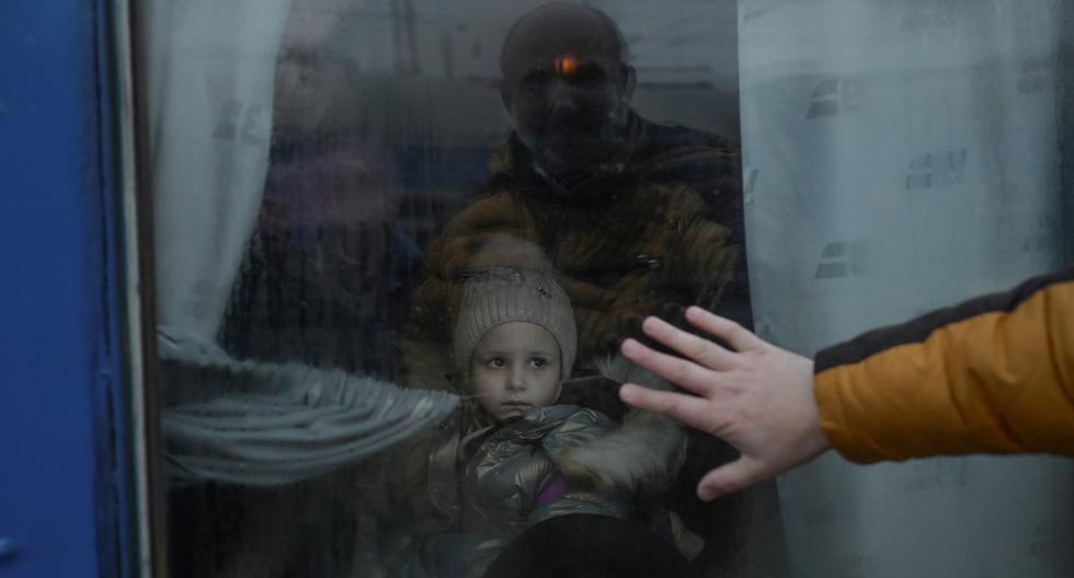 Un padre pone su mano en la ventana mientras se despide de su hija frente a un tren de evacuación en la estación central de trenes de Odessa, Ucrania, el 7 de marzo de 2022. (BULENT KILIC / AFP).
