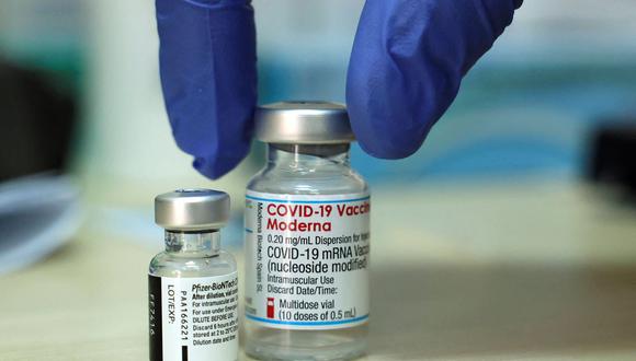 Un médico coloca sobre una mesa dos viales de vacunas contra el coronavirus COVID-19 de Pfizer-BioNTech (izquierda) y Moderna en un Centro Médico de Israel. (HAZEM BADER / AFP).