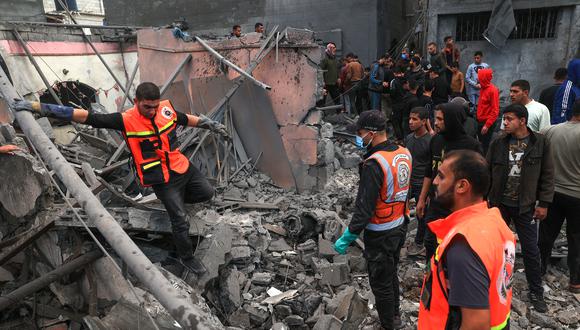 Los médicos palestinos buscan supervivientes entre los escombros de un edificio tras el bombardeo israelí en Rafah, en el sur de la Franja de Gaza, el 1 de diciembre de 2023, cuando los combates se reanudaron poco después de la expiración de una tregua de siete días entre Israel y militantes de Hamás. (Foto de SAID KHATIB / AFP)