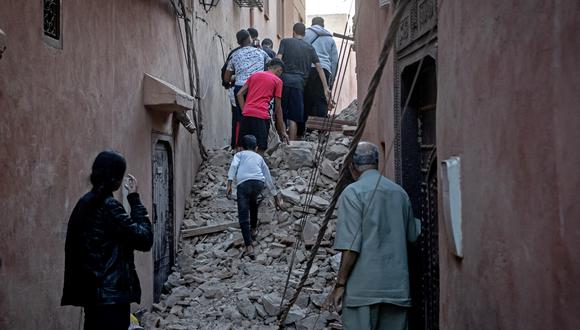 Los residentes evacuan entre los escombros en la antigua ciudad de Marrakech, dañada por el terremoto, el 9 de septiembre de 2023. (Foto de FADEL SENNA / AFP)