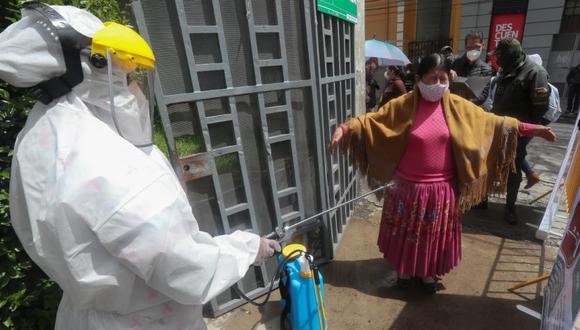 Un miembro del Sistema Departamental de Salud desinfecta a una mujer en la entrada del coliseo Julio Borelli en La Paz (Bolivia). (Foto: EFE/ Martín Alipaz/Archivo).