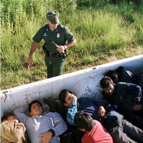 A border agent with migrants