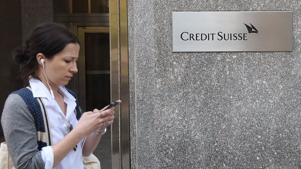 A woman passes in front of a branch of the Credit Suisse bank.  (GETTY IMAGES).
