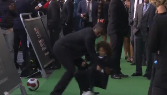 El niño rompió el protocolo del FIFA The Best e ingresó a la alfombra verde para jugar fútbol. En el momento menos esperado, ingresó Clarence Seedorf para tumbarlo y llevárselo del lugar. (Foto: captura de video)