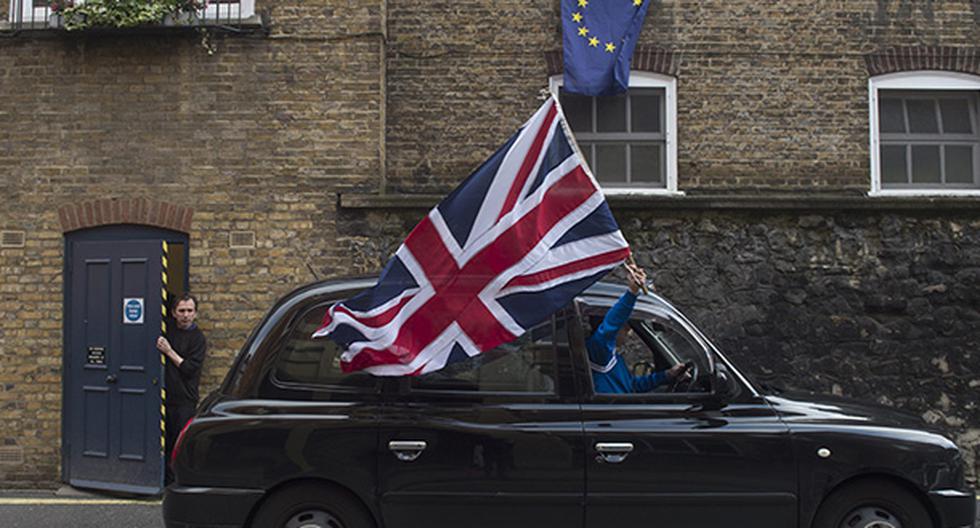 Un taxista londinense ondea una bandera británica mientras circula por una calle. (Foto: EFE)