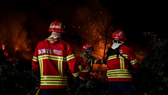 Los bomberos combaten un incendio forestal alrededor del pueblo de Eiriz en Baiao, al norte de Portugal.