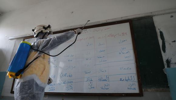 Defensa Civil de Siria esterilizan una escuela en el área de Ghosn al-Zeitun, en Afrin, como parte de una campaña para prevenir el coronavirus. (AFP / AAREF WATAD).
