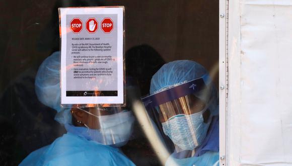 Los trabajadores de la salud con equipo de protección miran desde una carpa que fue construida para evaluar a las personas que podrían tener coronavirus  fuera del Brooklyn Hospital Center en Brooklyn, Nueva York, Estados Unidos. (REUTERS / Andrew Kelly).
