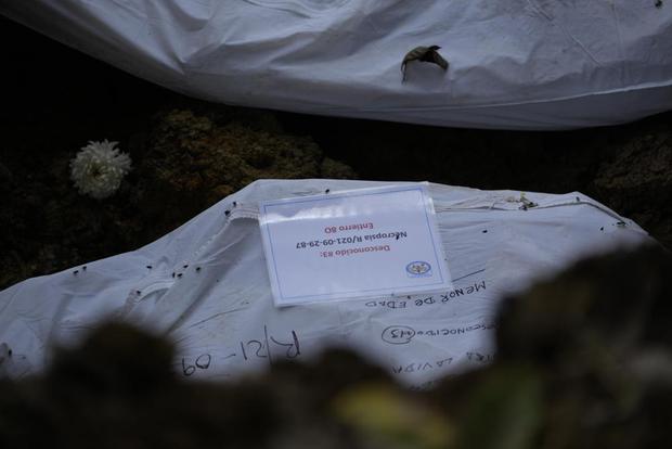 Una bolsa para cadáveres que contiene los restos de un migrante desconocido que murió tratando de cruzar la peligrosa jungla del Darién es enterrada en el cementerio de Guayabillo en Agua Fría, Panamá, el jueves 30 de septiembre de 2021. (Foto AP/Arnulfo Franco).