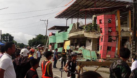 Los residentes miran un edificio dañado un día después de que un terremoto de 6.5 grados golpeara la ciudad de Kananga, Filipinas, en julio de 2017. (Foto referencial: AFP)