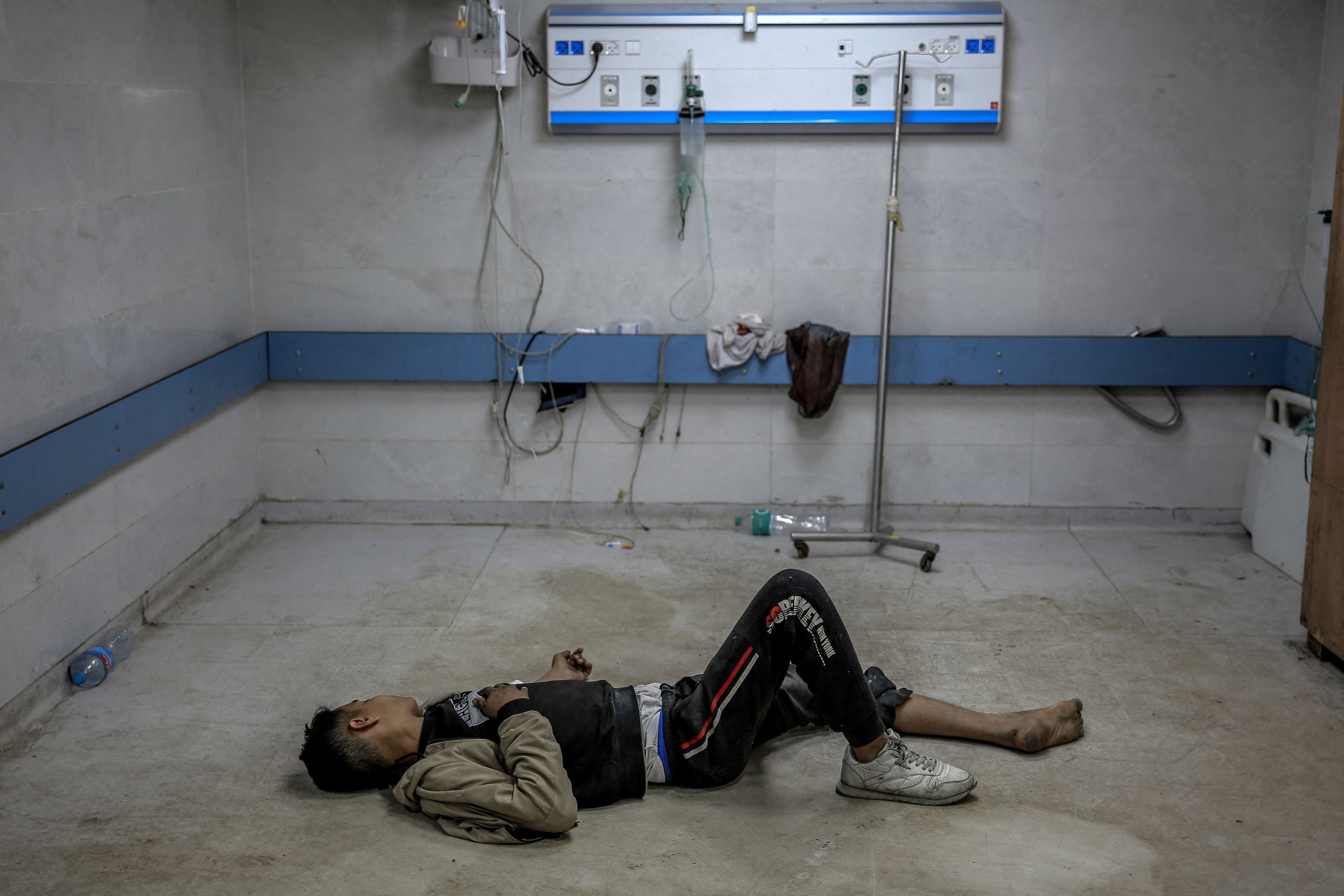 A young Palestinian man injured in an Israeli bombing lies on the ground as he waits for medical attention at Al Shifa Hospital in Gaza City, March 15, 2024. (AFP Photo).