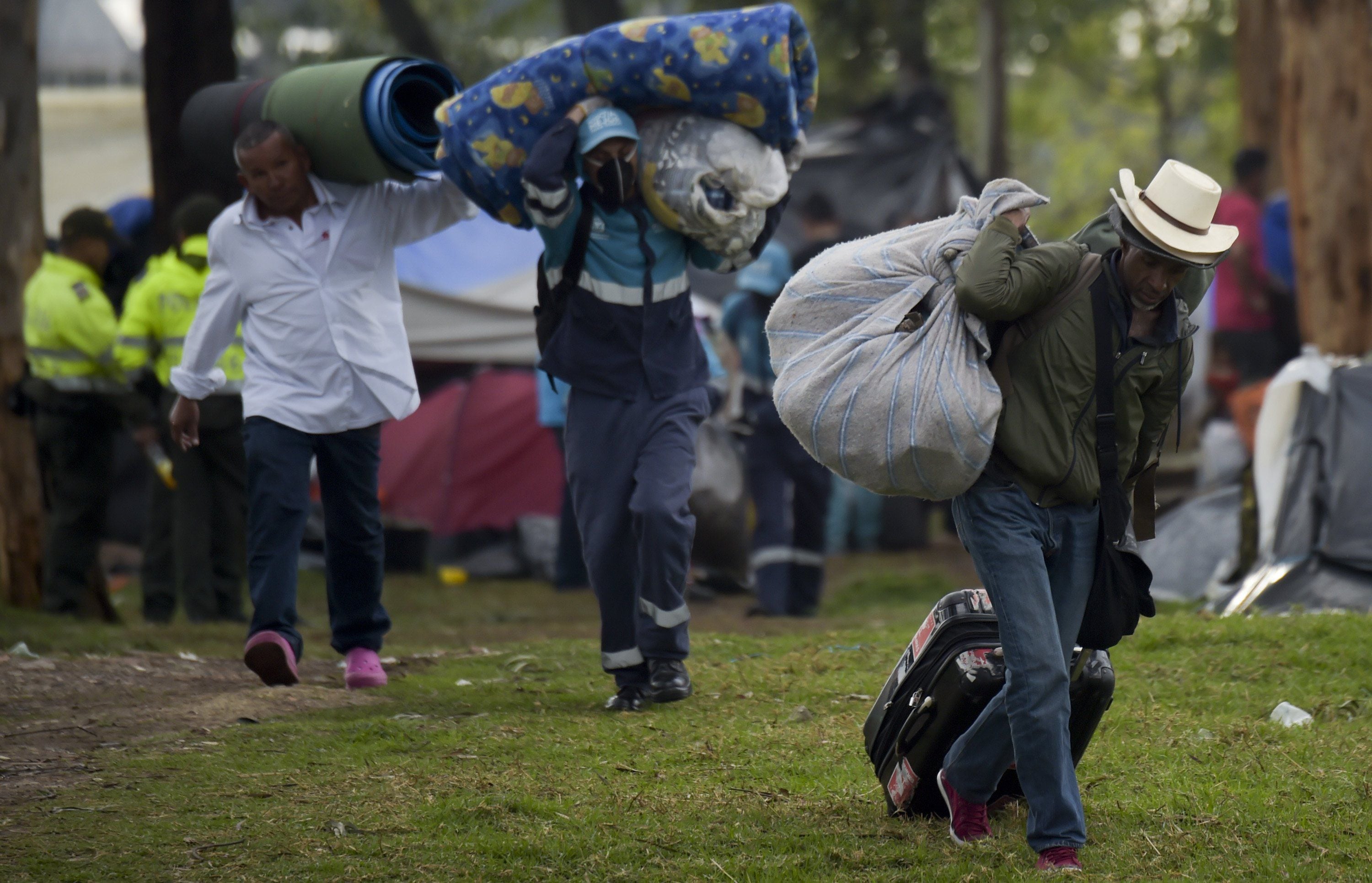 Venezuelan migrants carry their belongings upon arrival at a refugee camp in Bogotá.  AFP