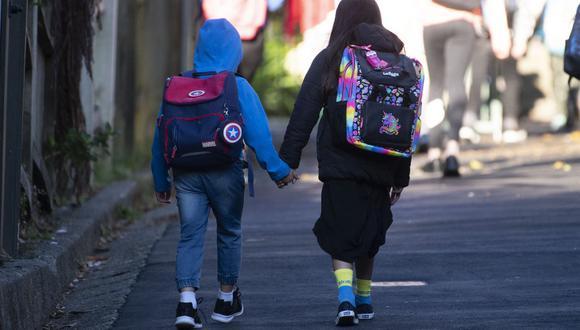 Niños en edad escolar se dirigen a la escuela después de que el gobierno permitió que las escuelas reabrieran según las pautas del Nivel 2 en Wellington el pasado 18 de mayo de 2020. (Marty MELVILLE / AFP)
