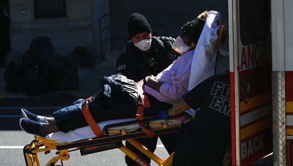 Los paramédicos llevan una camilla con un paciente en una ambulancia en el Brooklyn Hospital Center el 27 de marzo de 2020 en la ciudad de Nueva York.(Foto: AFP)