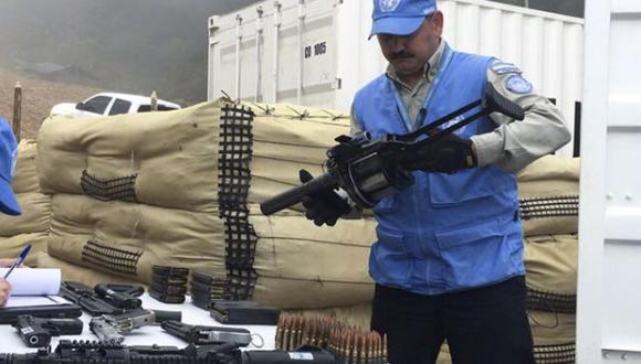 Un representante de la ONU revisa parte de las armas entregadas por las FARC. (AP).