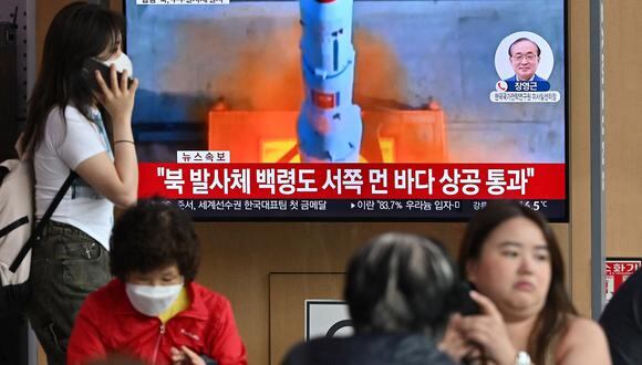 Gente mira una pantalla de televisión que muestra una transmisión de noticias con imágenes de archivo del lanzamiento de un cohete por parte de Corea del Norte, en la estación de tren de Seúl, Seúl, el 31 de mayo de 2023. (Foto de Jung Yeon-je / AFP)