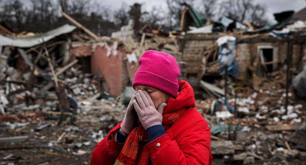 Irina Moprezova, de 54 años, reacciona frente a una casa que resultó destruida en un bombardeo aéreo ruso en la ciudad de Irpin, al noroeste de Kiev, el 13 de marzo de 2022. (DIMITAR DILKOFF / AFP).