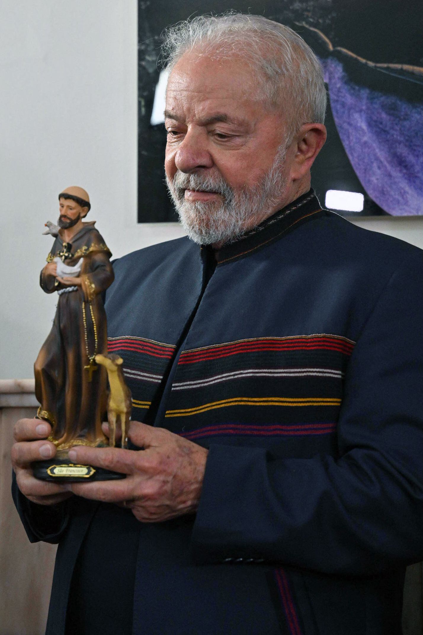 Lula da Silva holds an image of Saint Francis of Assisi that was given to him during a meeting with Franciscan friars to commemorate Saint Francis Day.  (Photo: AFP)