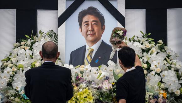 La gente deja flores y presenta sus respetos al ex primer ministro japonés Shinzo Abe fuera del Nippon Budokan en Tokio el 27 de septiembre de 2022. (Foto de Yuichi YAMAZAKI / AFP)