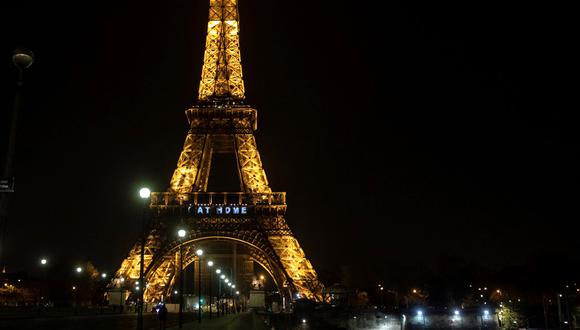 Una imagen muestra las palabras "Quédate en casa" en la Torre Eiffel durante una actividad en Francia destinado a frenar la propagación del COVID-19. (Foto: AFP).