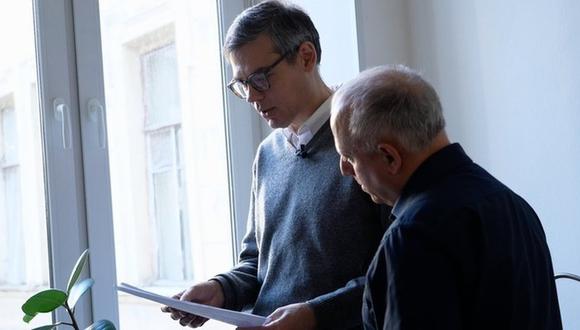 El profesor Denis Skopin (izquierda) muestra su carta de despido de la Universidad Estatal de San Petersburgo.