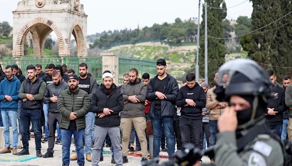 Las fuerzas de seguridad israelíes hacen guardia mientras los musulmanes palestinos realizan la oración del viernes al mediodía en una calle del este de Jerusalén el 23 de febrero de 2024, ya que se han impuesto restricciones de edad para acceder al recinto de la Mezquita de Al-Aqsa, en medio de las batallas en curso entre Israel y el grupo palestino. Hamás. (Foto de AHMAD GHARABLI / AFP)