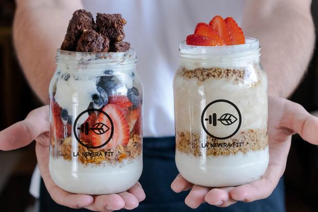 Healthy brownie parfait with homemade low-fat Greek yogurt and granola.  On the side, custard apple parfait with granola, Greek yogurt, strawberries and honey of your choice.  Both from The fridge fit.