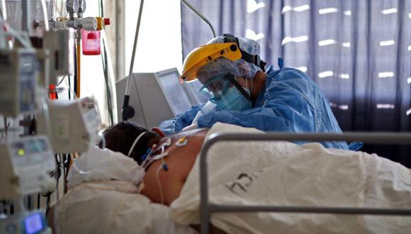Un trabajador de la salud revisa a un paciente con COVID-19 en la UCI del Hospital San Roque en Córdoba, Argentina. (Foto: archivo / AFP / Nicolás Aguilera).
