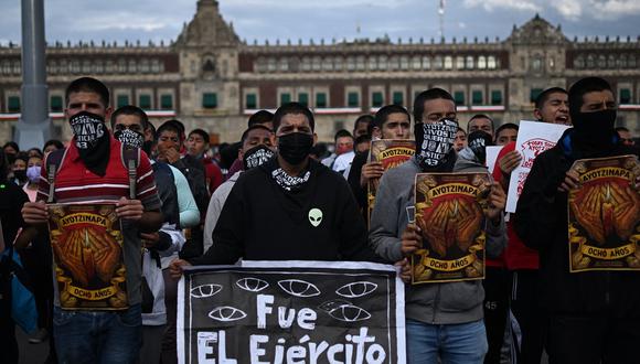 Personas marcha en la plaza Zócalo de la Ciudad de México el 26 de septiembre de 2022, para conmemorar el octavo aniversario de la desaparición de 43 estudiantes de la escuela docente en Ayotzinapa. (Foto de Rodrigo ARANGUA / AFP)
